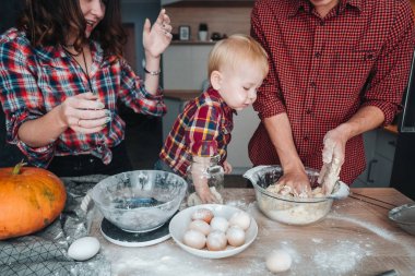 Baba, anne ve küçük oğlu bir pasta yemek