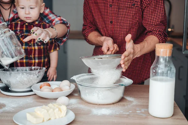 Dad sifts flour in the kitchen — Stock Photo, Image