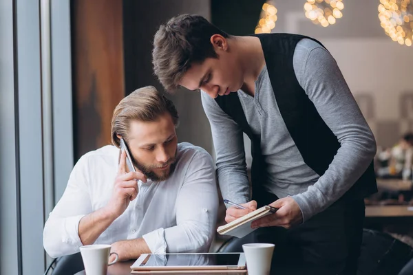 Dwóch biznesmenów, omawiając pracę i za pomocą tabletu — Zdjęcie stockowe