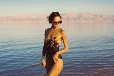 Genç bir kadın doğal mineral çamurunun tadını çıkarıyor.