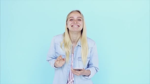 Imagen de la joven feliz de pie aislada sobre fondo azul . — Vídeos de Stock