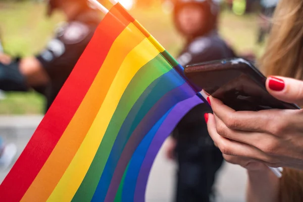 La mano sostiene una bandera gay lgbt en el festival de desfile de orgullo gay LGBT — Foto de Stock