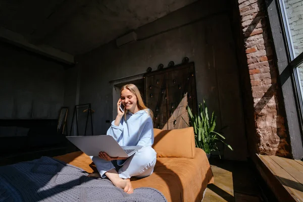 Sorridente donna attraente sdraiata sul letto a parlare da smartphone — Foto Stock