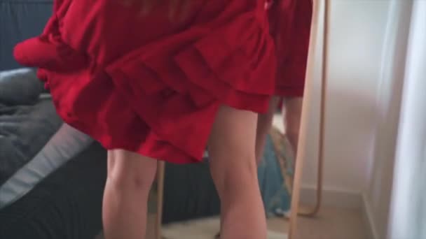 Junge glückliche Frau probiert ein neues Kleid an, um es vor dem Spiegel zu tragen — Stockvideo