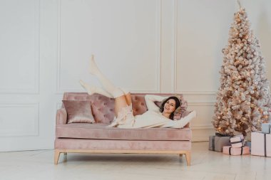 Güzel kadın kanepede yatıyor.