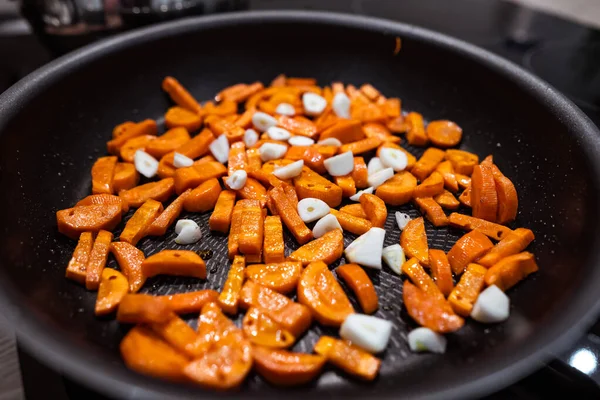 Morötter, vitlök i en kastrull före matlagning. Stäng slöja — Stockfoto