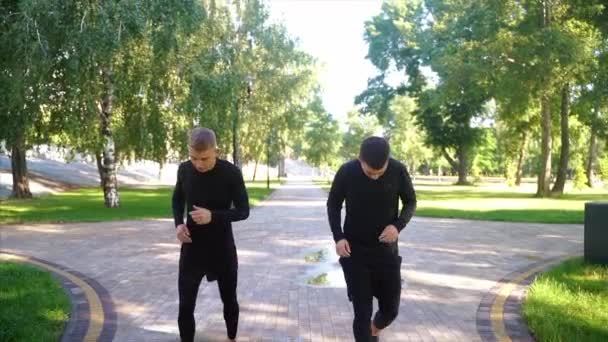 Two friends running through the forest on a jogging trail. — Stock Video