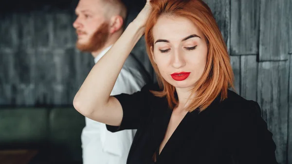 Uma jovem mulher e seu namorado estão posando para a câmera dentro de casa . — Fotografia de Stock