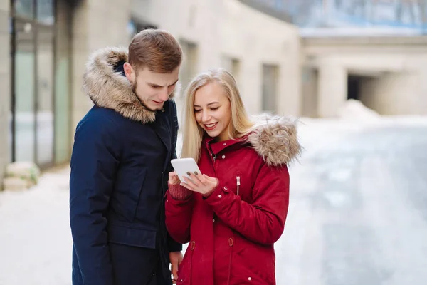 Fille tenant un téléphone dans sa main et ils regardent le smartphone . — Photo