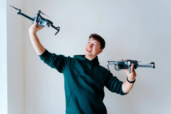 Killen håller två quadrocopters mot en vägg — Stockfoto