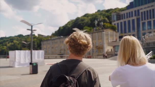 A guy and a girl walk along the street together. — Stock Video