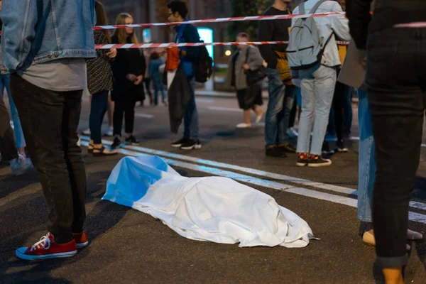 ร่างกายมนุษย์ปกคลุมด้วยผ้าปูที่นอนอยู่บนถนน . — ภาพถ่ายสต็อก