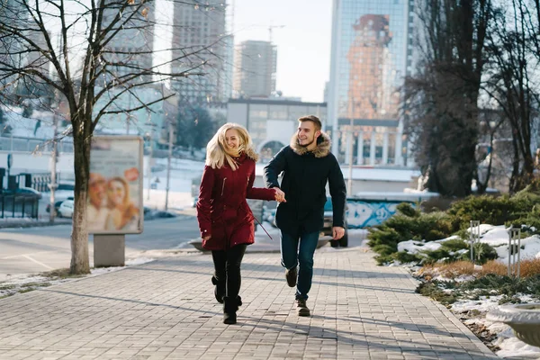 Casal feliz andando na rua no inverno em uma cidade — Fotografia de Stock