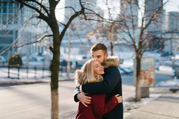 Jovem sorrindo feliz casal europeu abraçando no inverno — Fotografia de Stock