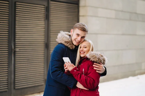 Jovem sorrindo feliz casal europeu abraçando no inverno — Fotografia de Stock