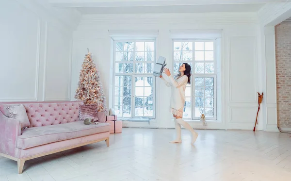 Vacker ung flicka i vit klänning poserar på kameran. Julkoncept — Stockfoto