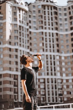 Genç ve çekici hippi bir adam yaz günü soğuk bir içki içer..