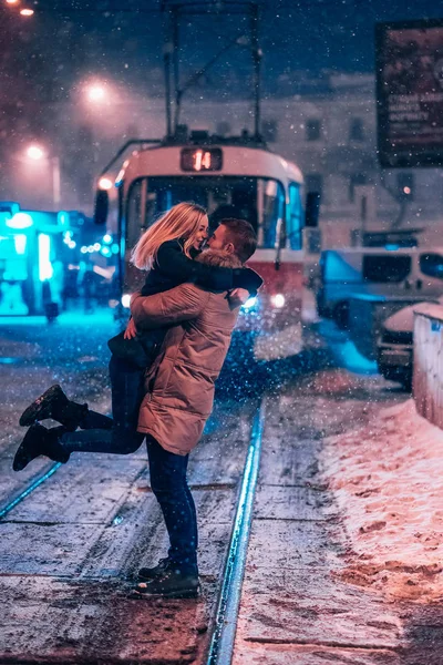 Молодая взрослая пара на заснеженной трамвайной линии — стоковое фото