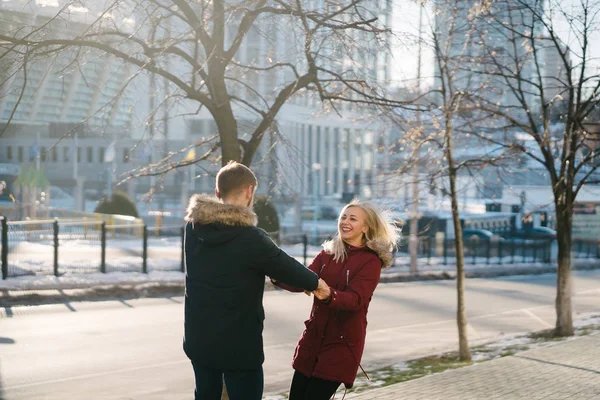 Joyeux couple marchant dans la rue en hiver dans une ville — Photo