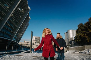 Bir kasabada kışın sokakta yürüyen mutlu çift.