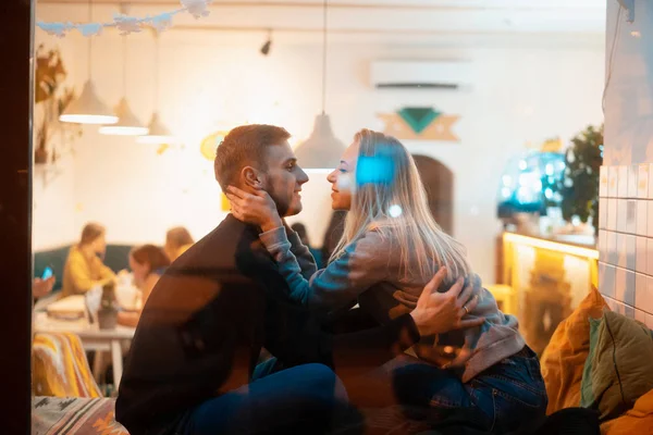 Photo through window. Young couple in cafe with stylish interior — Stock Photo, Image