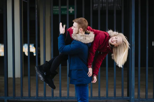 Guy on the shoulder is carrying the girl, winter outdoors. — Stock Photo, Image