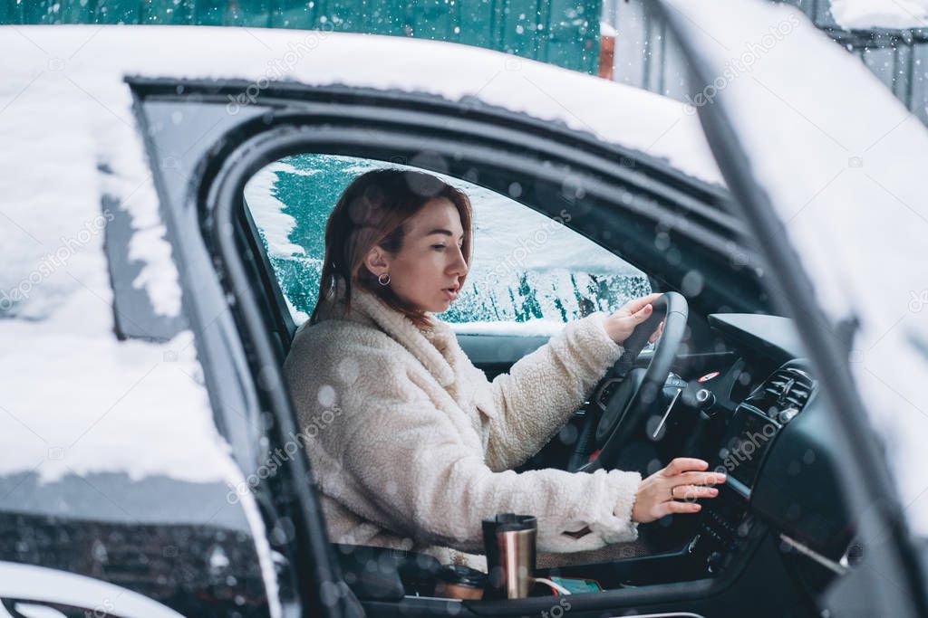 Attractive woman driver nsitting behind the steering wheel in her car