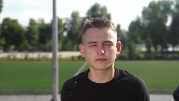 Joven modelo de hombre guapo deportivo en camisa negra mirando a la cámara — Vídeos de Stock