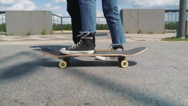 その男はスケートボードにガールフレンドを教えている。ヒップスターの日. — ストック動画