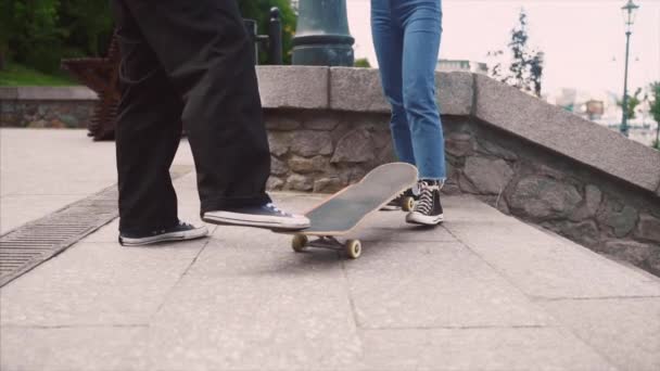 Hij leert z 'n vriendin skateboarden. Datum van de hipsters. — Stockvideo