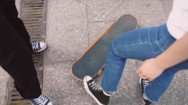 El tipo está enseñando a su novia a patinar. Fecha de los hipsters . — Vídeos de Stock