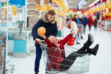 Genç yakışıklı bir adam bir kızı tramvayda bir süpermarkete bindiriyor.