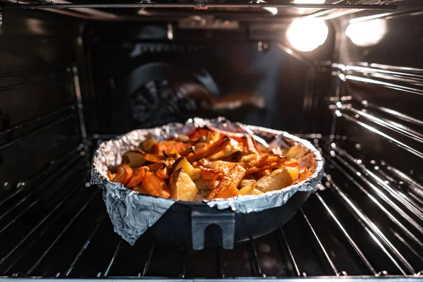 Запеченный картофель с морковью и другими специями в сковороде. — стоковое фото