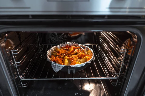 Bakad potatis med morot och andra kryddor i stekpannan. — Stockfoto