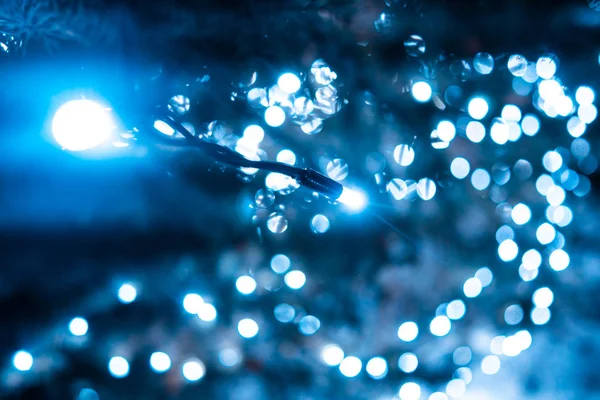 Árvore de Natal com cones em uma rua de cidade iluminada com uma grinalda. — Fotografia de Stock