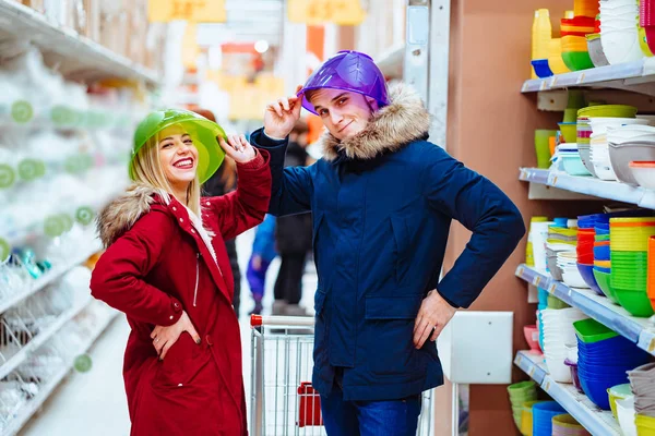 Giovane coppia scherzare con ciotole in un supermercato — Foto Stock