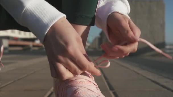 2019年5月7日、ウクライナ、キエフ。練習前にランニングシューズで靴ひもを結ぶ女性の手. — ストック動画