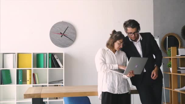 Man and woman discuss something in the office. Look at a laptop — Stock Video