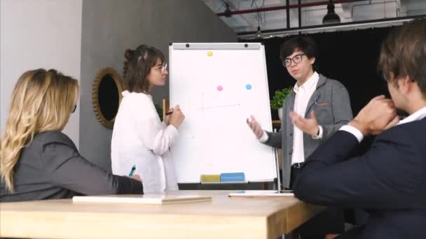 Επιχειρηματίες με λευκό πίνακα συζητούν στρατηγική σε μια συνάντηση — Αρχείο Βίντεο
