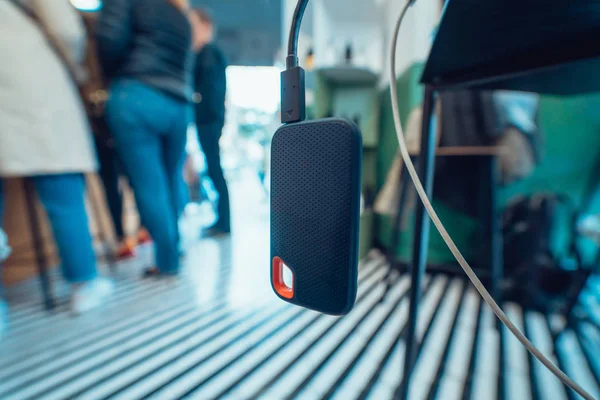 Powerbank battery in gray color charging devise through black USB cable on table — Stock Photo, Image