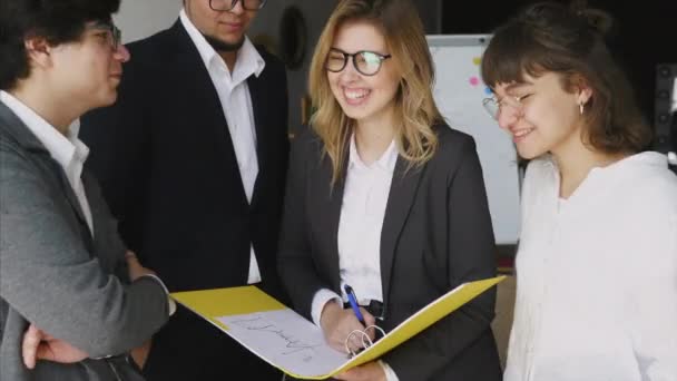 Grupo de jóvenes inspirados de pie y discutiendo un nuevo proyecto — Vídeos de Stock