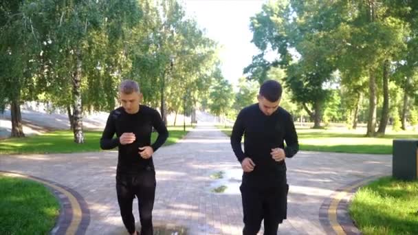 Dos amigos corriendo por el bosque en un sendero de jogging . — Vídeos de Stock