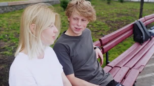 Fille de détente avec son petit ami assis sur un banc — Video