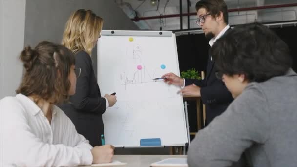 Ondernemers met whiteboard bespreken strategie tijdens een bijeenkomst — Stockvideo