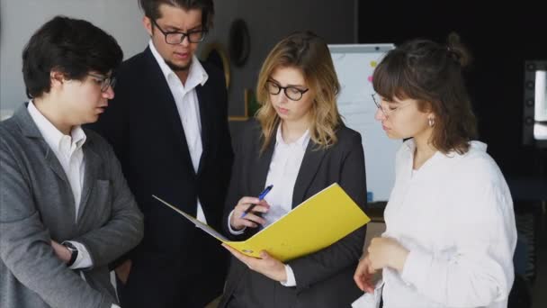 Grupo de jovens inspirados que estão de pé e discutem novo projeto — Vídeo de Stock