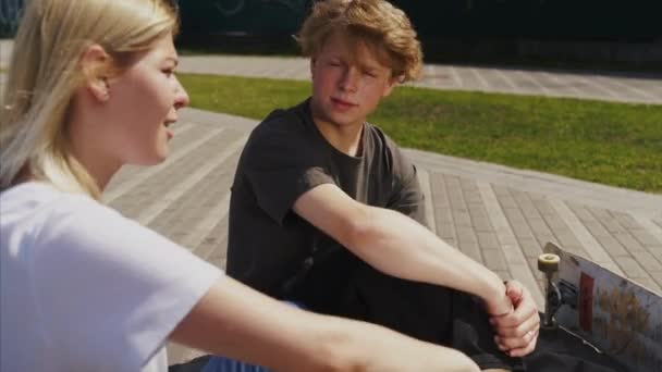 Guy and girl are sitting on the street and talking — Stock Video