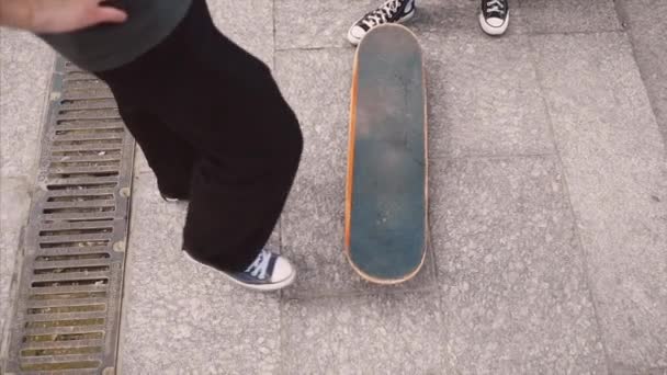 The guy is teaching his girlfriend to skateboard. Date of hipsters. — Stock Video