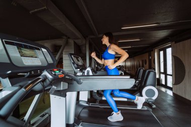 kadın spor salonunda treadmill egzersiz yaparak
