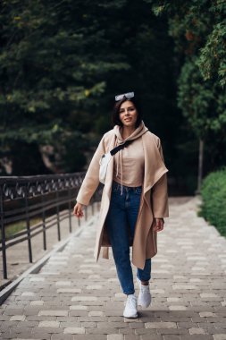 Parktaki güzel, modaya uygun kadının yakın portresi..