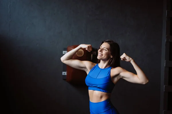 Mujer en forma posando en la cámara. Entrenadora personal mostrando su forma. Belleza del deporte moderno . —  Fotos de Stock